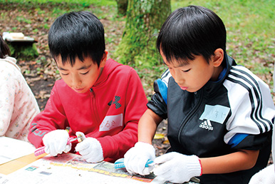 男の子２人が間伐材を使ってえんぴつを作製している写真