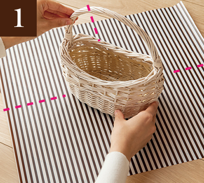 １ 大きめの正方形にカットした布の中央にバスケットを置いている様子の写真